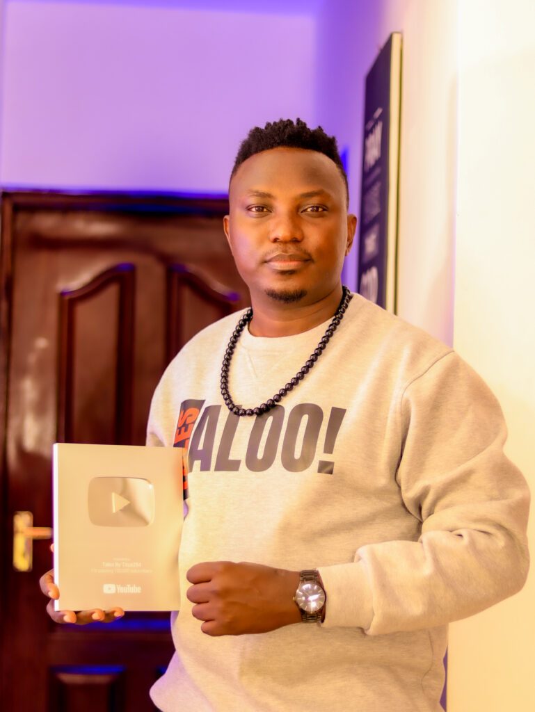 Titus Lichambi Lusega holding the YouTube Silver Play Button